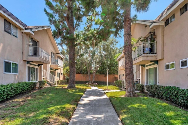 surrounding community with fence and a lawn