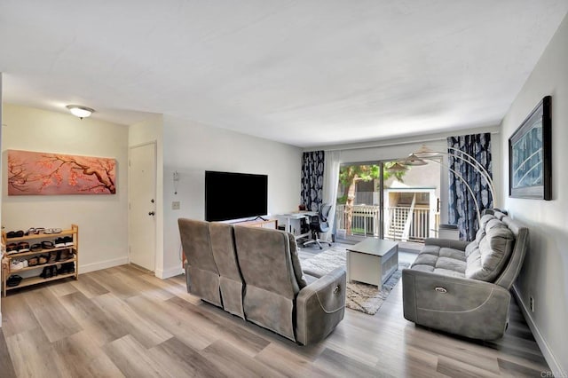 living area with light wood-style flooring and baseboards