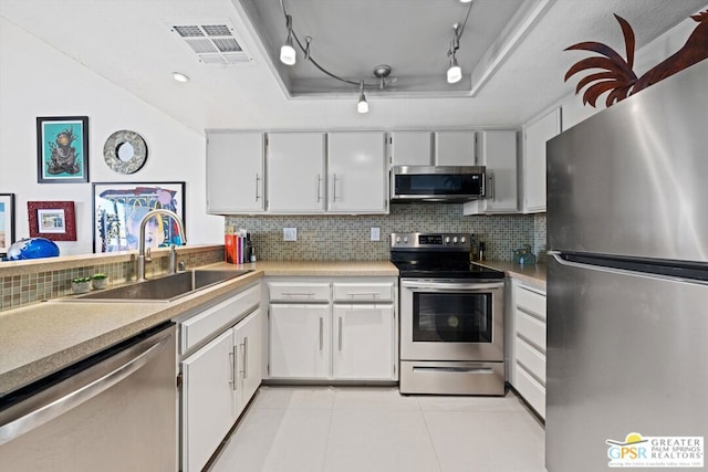 kitchen featuring white cabinetry, sink, stainless steel appliances, backsplash, and light tile patterned floors