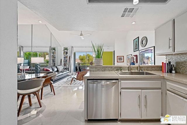 kitchen with decorative backsplash, a textured ceiling, kitchen peninsula, and stainless steel dishwasher