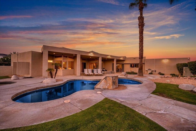 pool at dusk with a patio