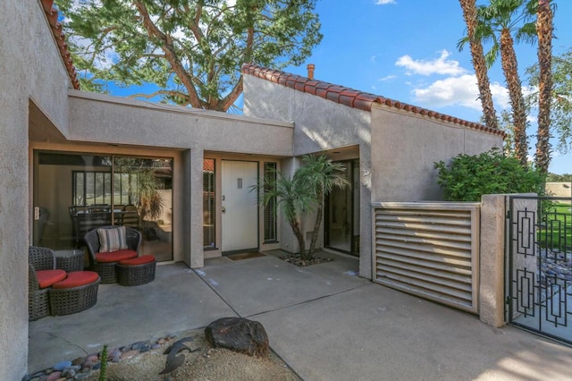 view of exterior entry with a patio area