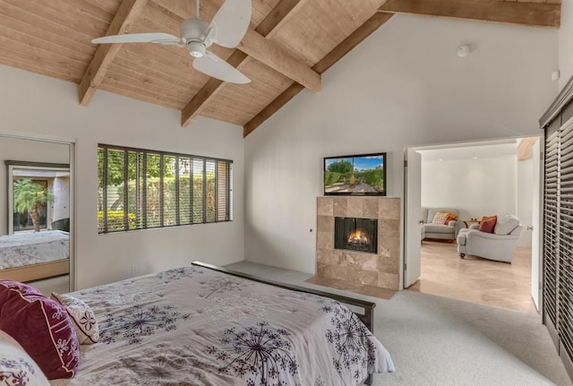 bedroom with ceiling fan, beam ceiling, a fireplace, and high vaulted ceiling