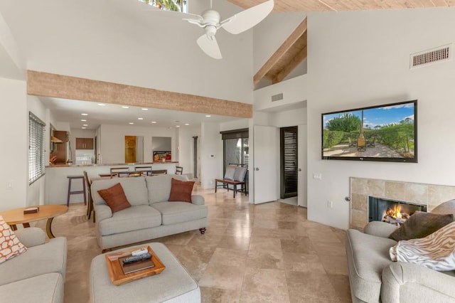 living room with a fireplace, high vaulted ceiling, ceiling fan, and beamed ceiling