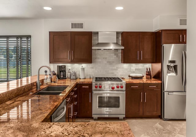 kitchen featuring stone counters, sink, wall chimney exhaust hood, decorative backsplash, and appliances with stainless steel finishes