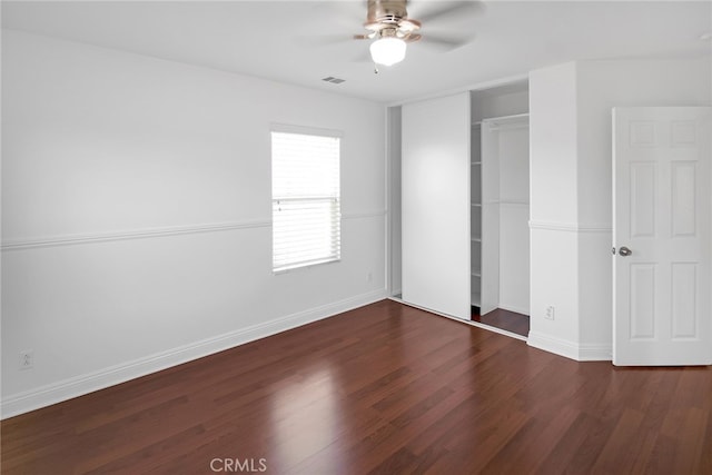 unfurnished bedroom with dark hardwood / wood-style floors, ceiling fan, and a closet