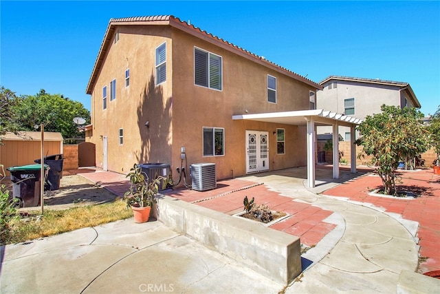 rear view of property featuring cooling unit, a patio area, and french doors