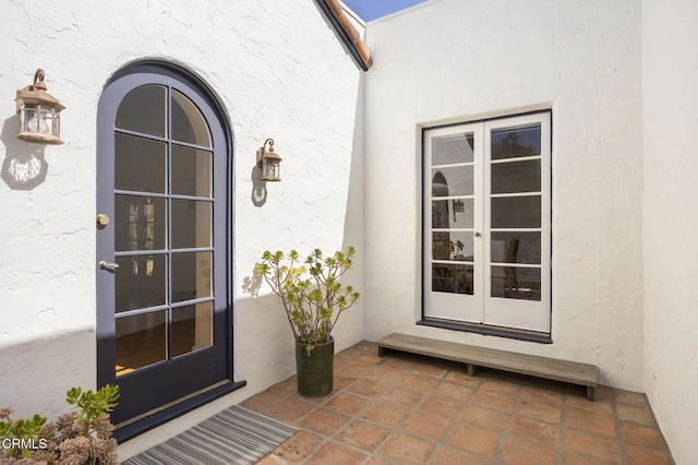 entrance to property with french doors and stucco siding