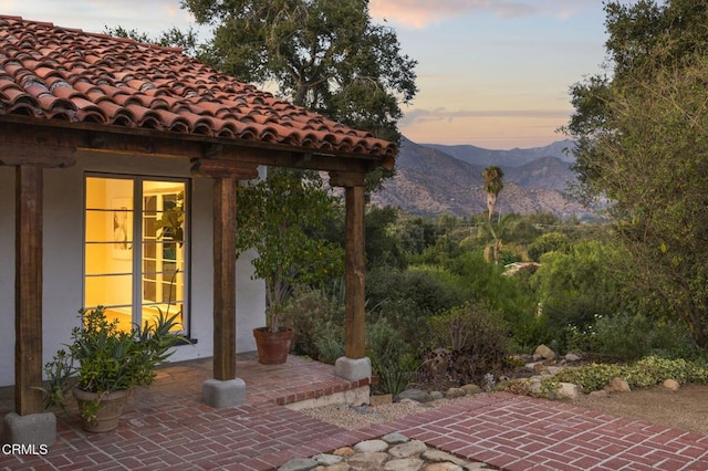 patio terrace at dusk featuring a mountain view