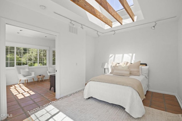 bedroom with tile patterned floors, a skylight, baseboards, and visible vents