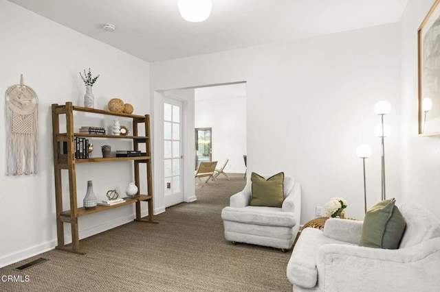 sitting room with carpet flooring, baseboards, and visible vents