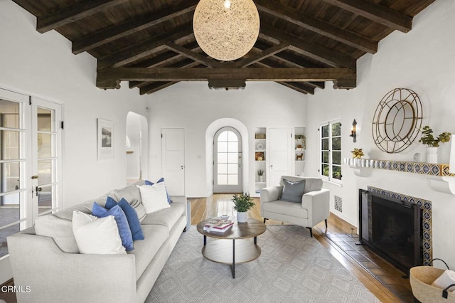 living room with wooden ceiling, wood finished floors, a fireplace, and arched walkways