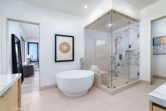 bathroom with plus walk in shower, wood-type flooring, and vanity