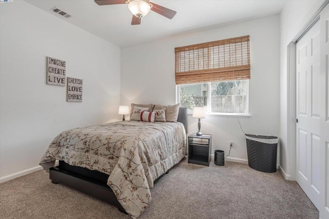 bedroom featuring light colored carpet, ceiling fan, and a closet