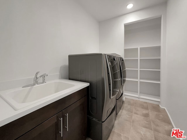 laundry area featuring washing machine and clothes dryer, sink, and cabinets