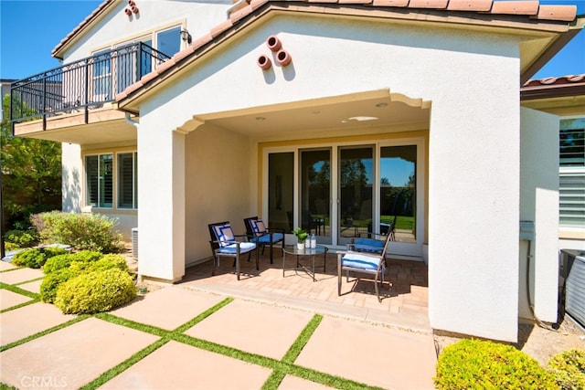 rear view of house featuring a balcony and a patio area