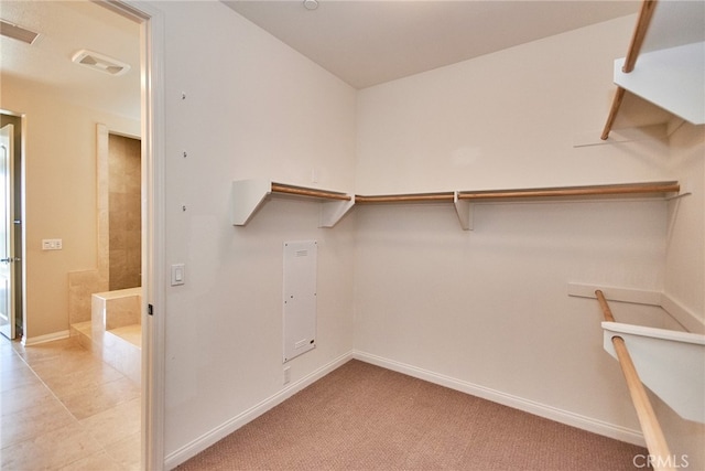 walk in closet with light tile patterned floors