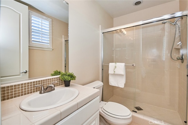 bathroom with backsplash, vanity, toilet, and an enclosed shower