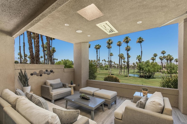 interior space featuring beam ceiling, hardwood / wood-style floors, a textured ceiling, and a water view