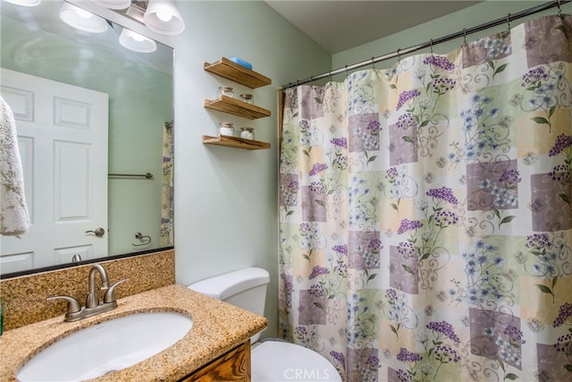 bathroom with curtained shower, vanity, and toilet