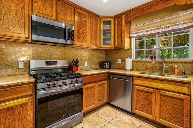 kitchen featuring stainless steel appliances, tasteful backsplash, light tile patterned floors, and sink