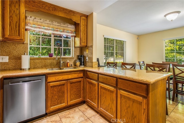 kitchen featuring backsplash, dishwasher, kitchen peninsula, and sink