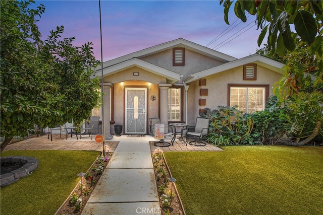 view of front of property with a lawn and a patio area