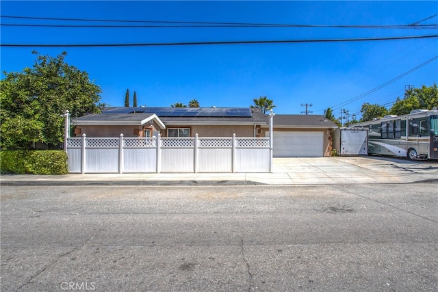 view of front of property featuring a garage and solar panels