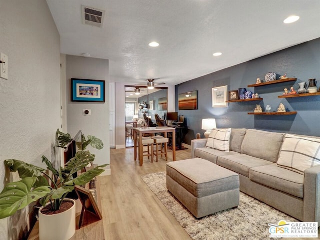 living room featuring ceiling fan and light wood-type flooring