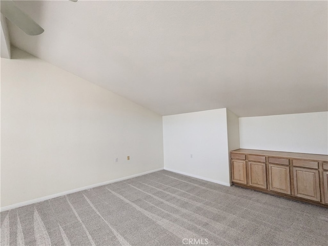 additional living space featuring light carpet and lofted ceiling