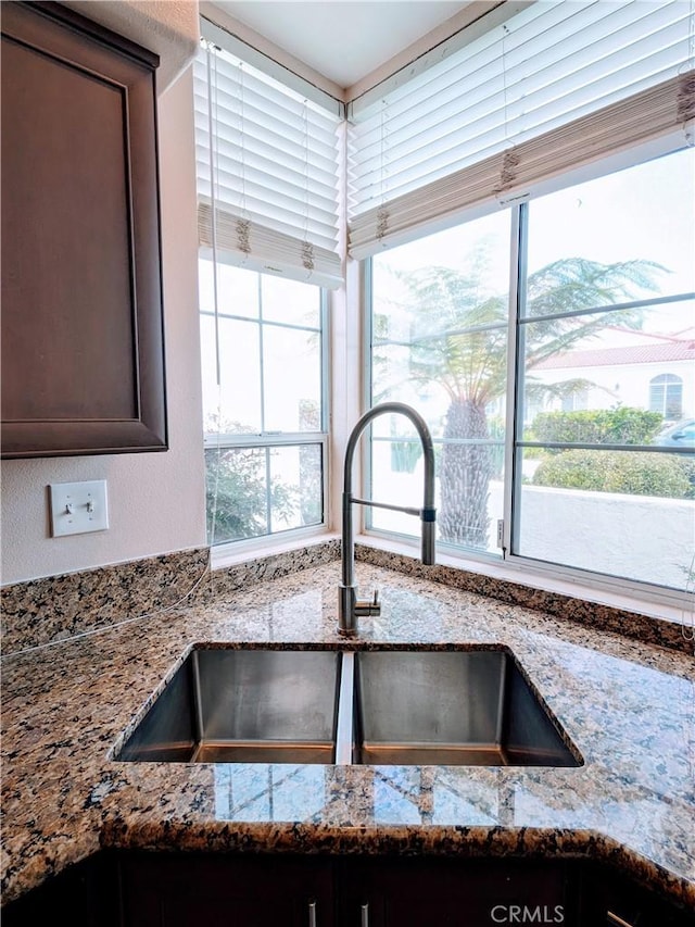3310 Tripoli Way, Oceanside, CA 92056 - kitchen view of a sink, stone counters, and dark brown cabinets