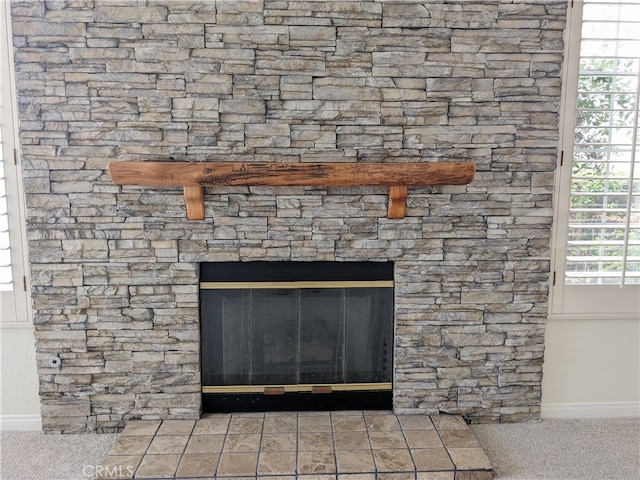 interior details featuring carpet and a stone fireplace