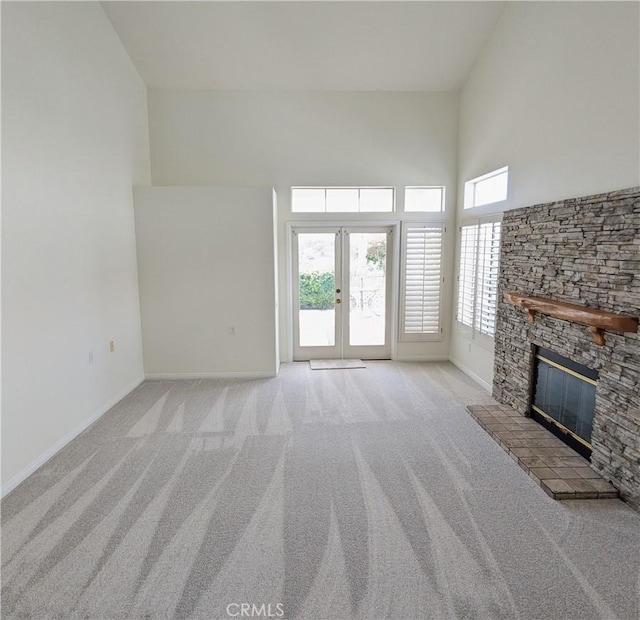 3310 Tripoli Way, Oceanside, CA 92056 - unfurnished living room with light carpet, a fireplace, a high ceiling, baseboards, and french doors