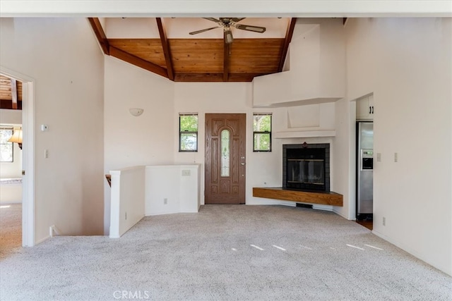 unfurnished living room with wood ceiling, ceiling fan, light colored carpet, and high vaulted ceiling