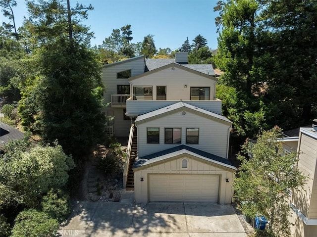 1550 Pineridge Dr, Cambria, CA 93428 - view of front of house featuring an attached garage, board and batten siding, stairway, a balcony, and driveway