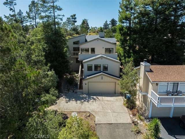 1550 Pineridge Dr, Cambria, CA 93428 - view of front of property featuring a garage, board and batten siding, a chimney, a balcony, and driveway