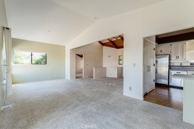 empty room with lofted ceiling and dark colored carpet