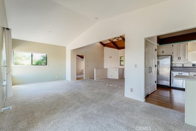 1550 Pineridge Dr, Cambria, CA 93428 - unfurnished living room with visible vents, lofted ceiling, and dark colored carpet