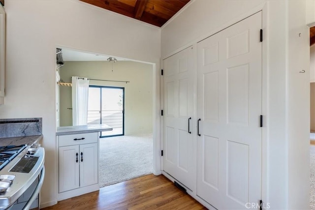 1550 Pineridge Dr, Cambria, CA 93428 - kitchen featuring wood ceiling, light wood-type flooring, light countertops, stainless steel gas range, and white cabinetry