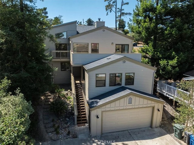 1550 Pineridge Dr, Cambria, CA 93428 - view of front of property featuring an attached garage, board and batten siding, stairway, a chimney, and driveway