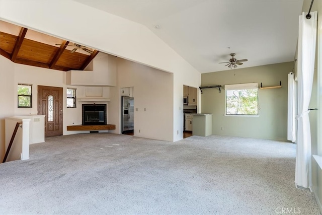 unfurnished living room with wood ceiling, ceiling fan, light carpet, and high vaulted ceiling