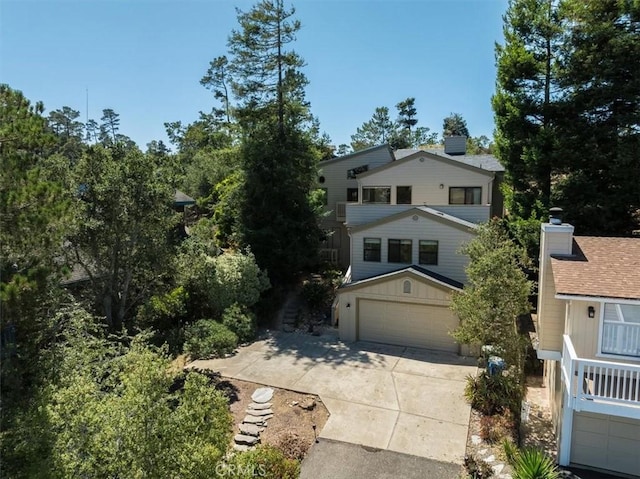 1550 Pineridge Dr, Cambria, CA 93428 - view of front facade featuring concrete driveway, an attached garage, board and batten siding, and a chimney