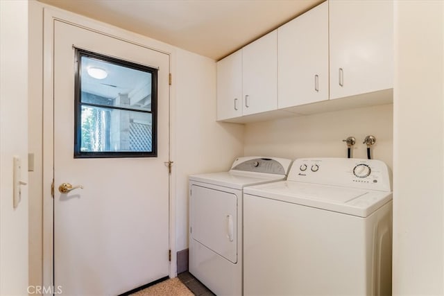 laundry room with separate washer and dryer and cabinets