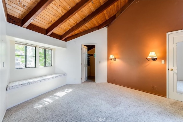 carpeted empty room with wooden ceiling and lofted ceiling with beams