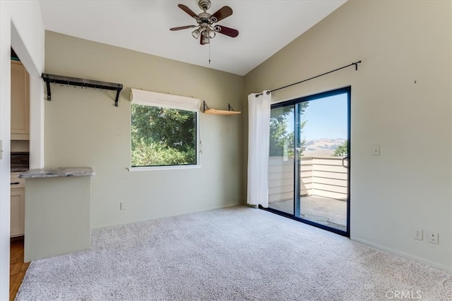 unfurnished living room featuring light carpet, lofted ceiling, and ceiling fan