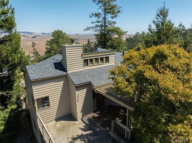 1550 Pineridge Dr, Cambria, CA 93428 - rear view of property featuring a mountain view, a shingled roof, and a chimney