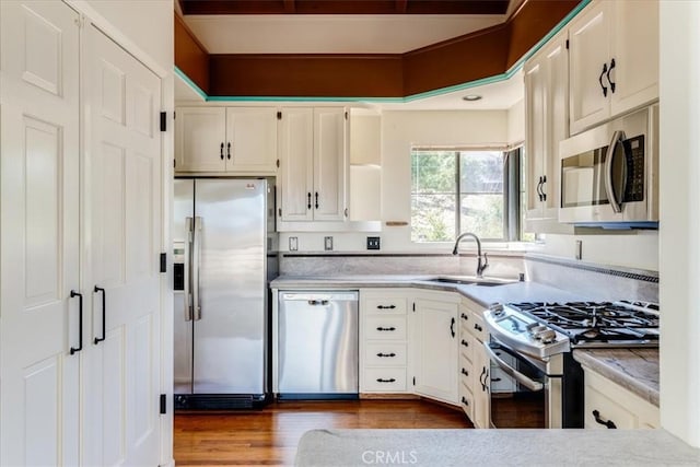 1550 Pineridge Dr, Cambria, CA 93428 - kitchen with dark wood-style floors, light countertops, white cabinetry, a sink, and stainless steel appliances