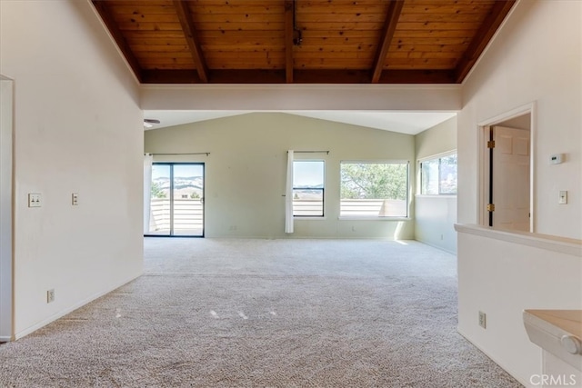 spare room with vaulted ceiling with beams, light colored carpet, and a healthy amount of sunlight