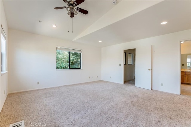 empty room with lofted ceiling, ceiling fan, and light carpet