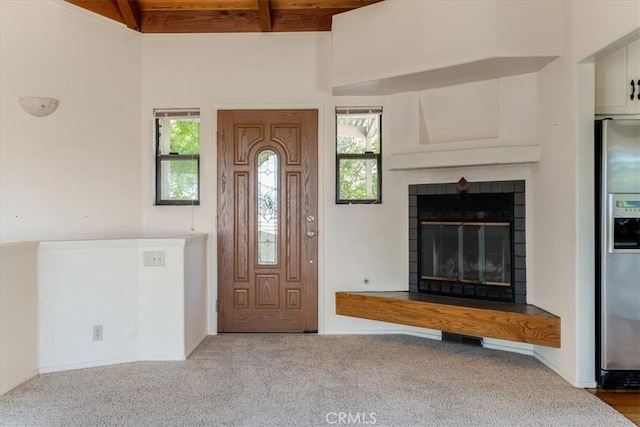1550 Pineridge Dr, Cambria, CA 93428 - carpeted foyer entrance featuring lofted ceiling with beams, a glass covered fireplace, a wealth of natural light, and wood ceiling
